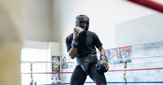 Boxer in headgear training in the ring